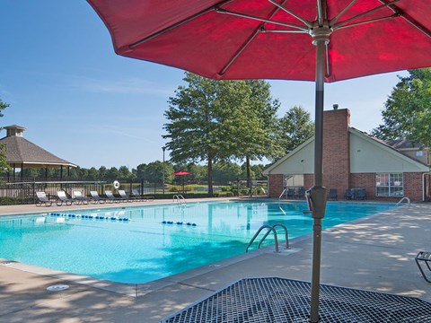 our apartments have a resort style pool with chairs and an umbrella