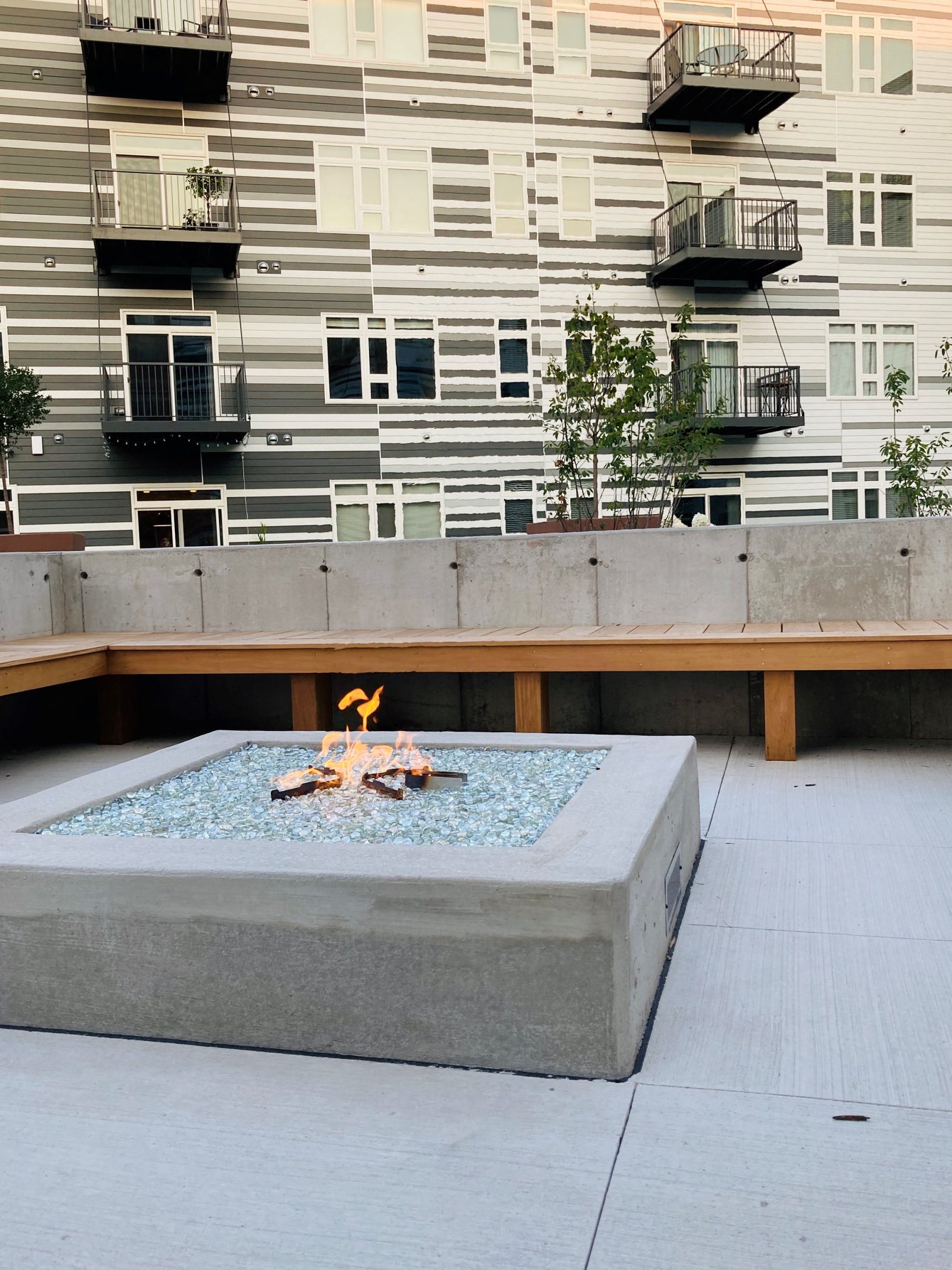 a fire pit on a sidewalk in front of a building