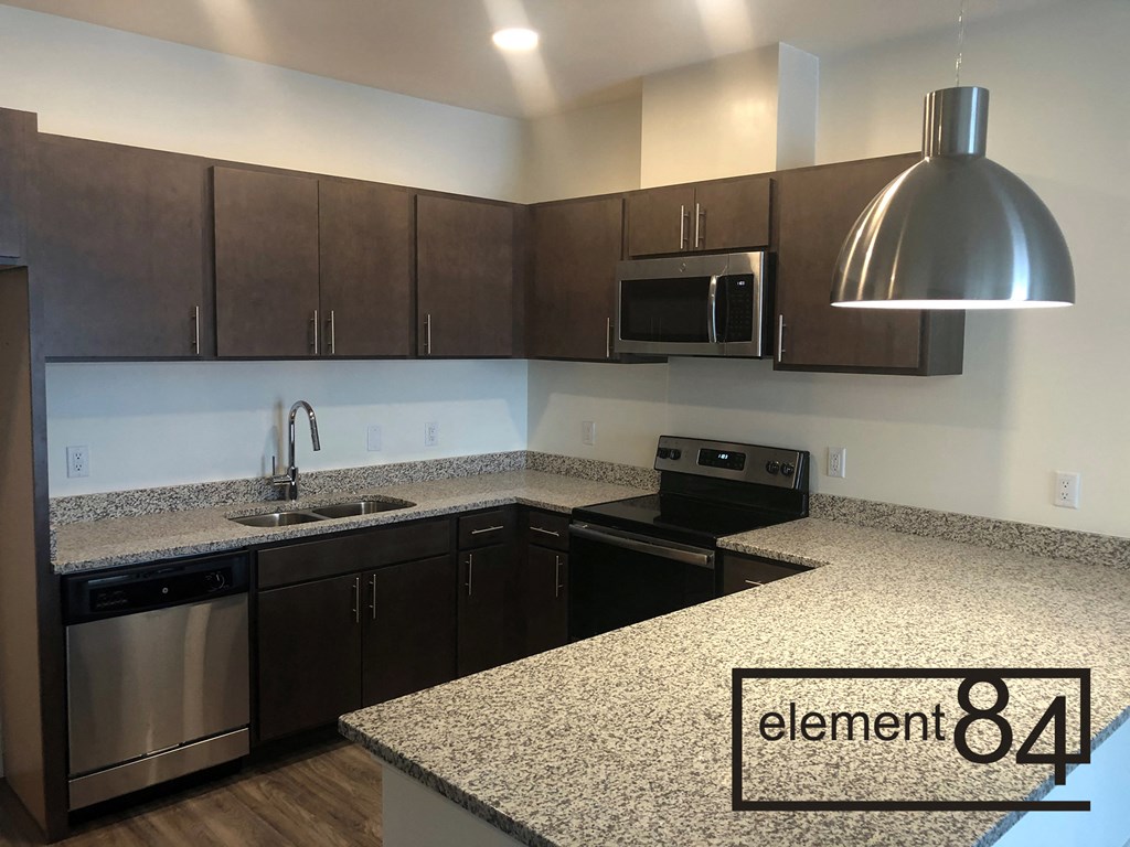 a kitchen with granite counter tops and wooden cabinets