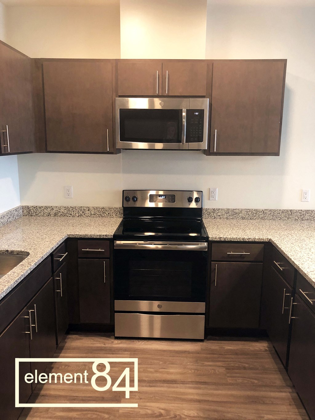 an empty kitchen with a stove and a microwave