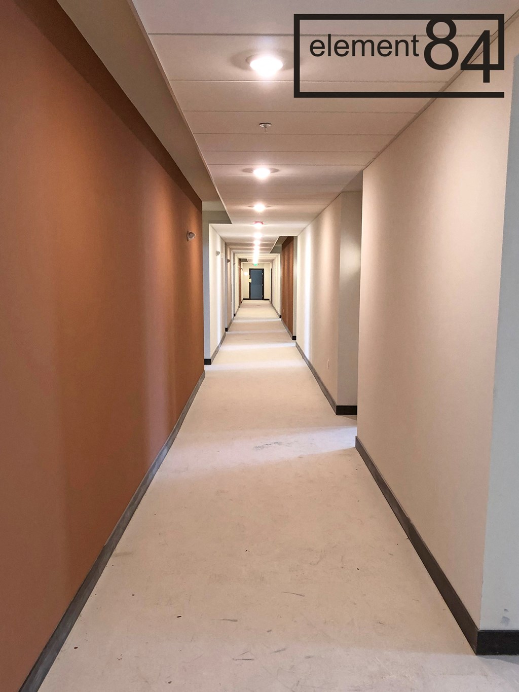 a long hallway with brown walls and white floors and a sign that reads element 84