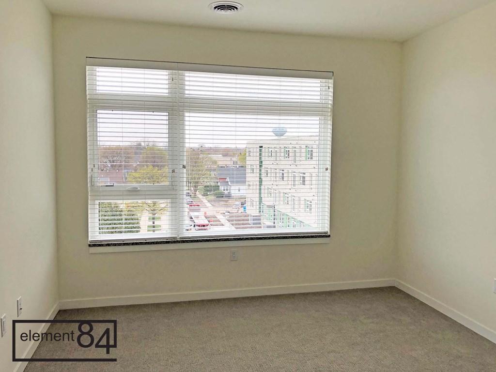 an empty room with a large window overlooking the city