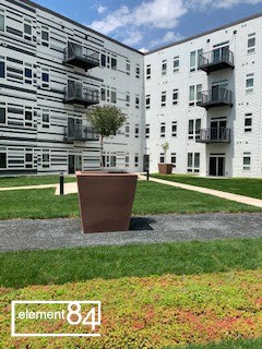 an image of an apartment building with a flower pot in front of it