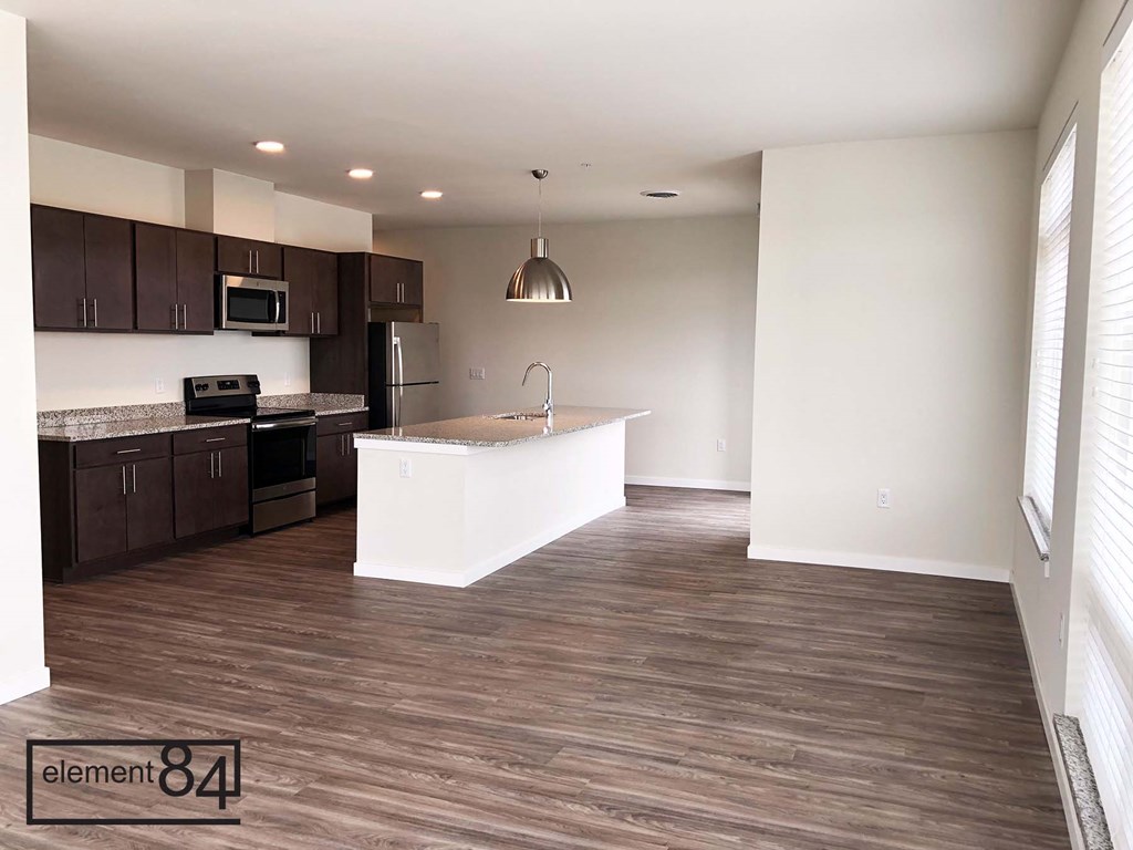 an empty kitchen and living room with a white counter top