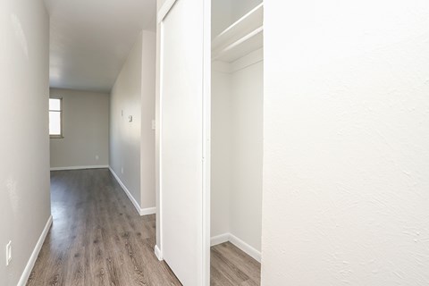 A long hallway with wood floors and white walls.