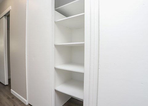 A white shelving unit with multiple shelves is open.