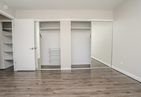 A white closet with a white door and a white shelf.