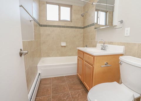 A bathroom with a white toilet, a white sink, and a white bathtub.