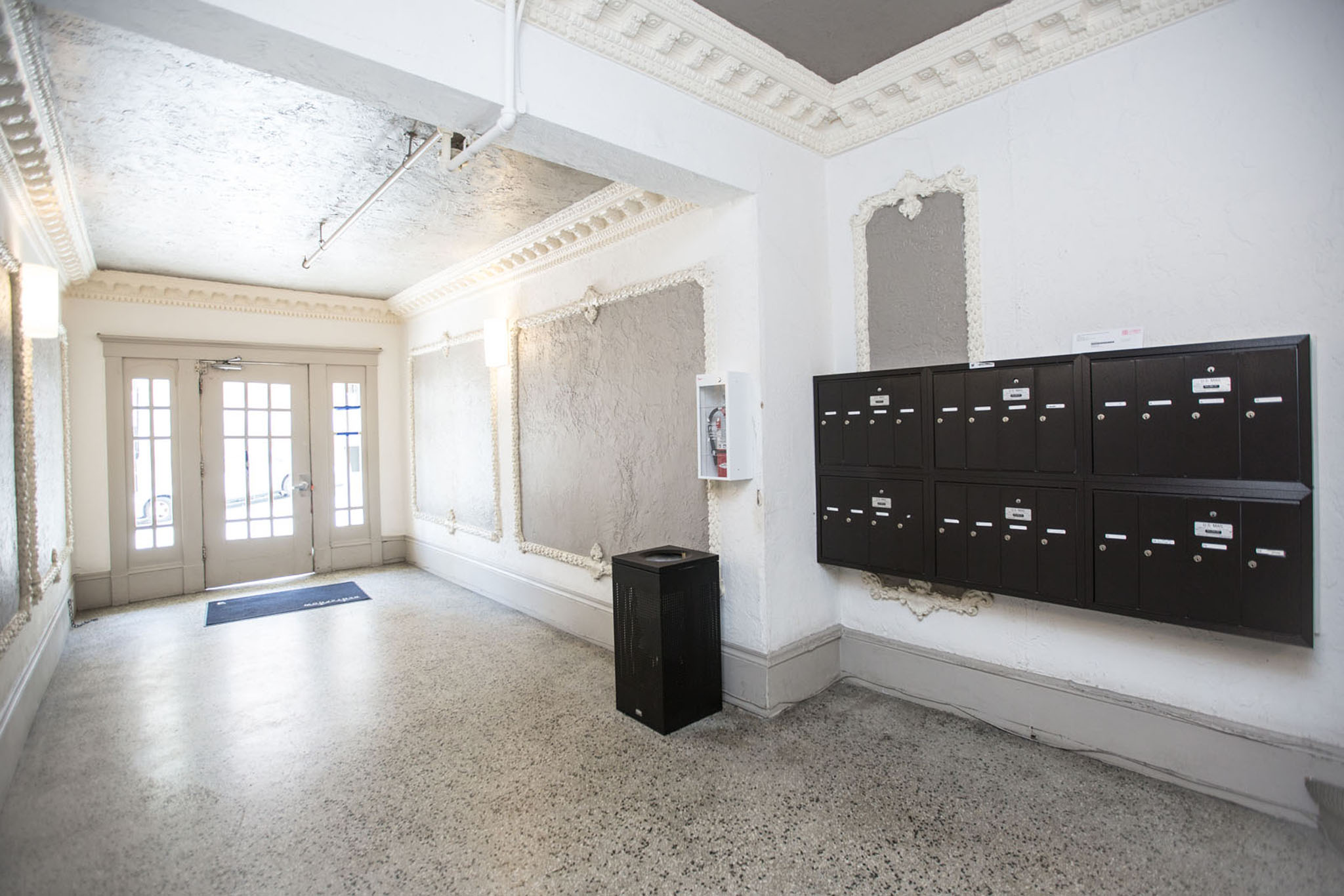 A room with a blue mat on the floor and a black cabinet.