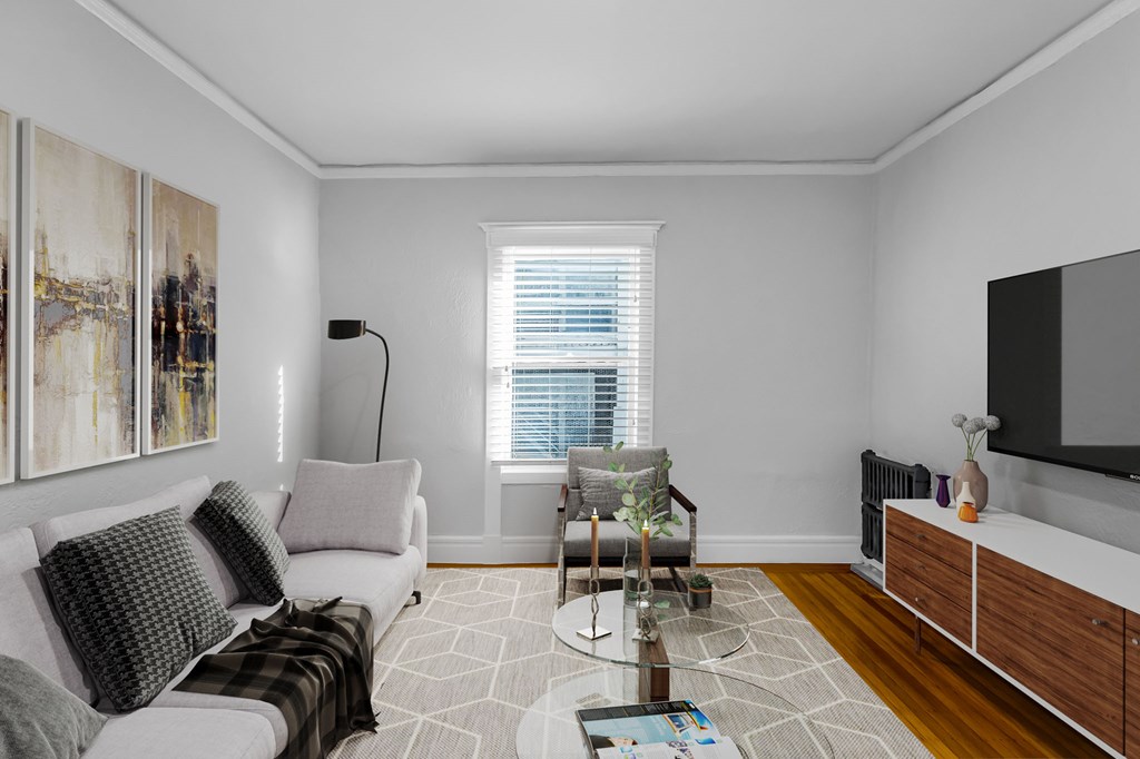 A living room with a couch, coffee table, and a painting on the wall.