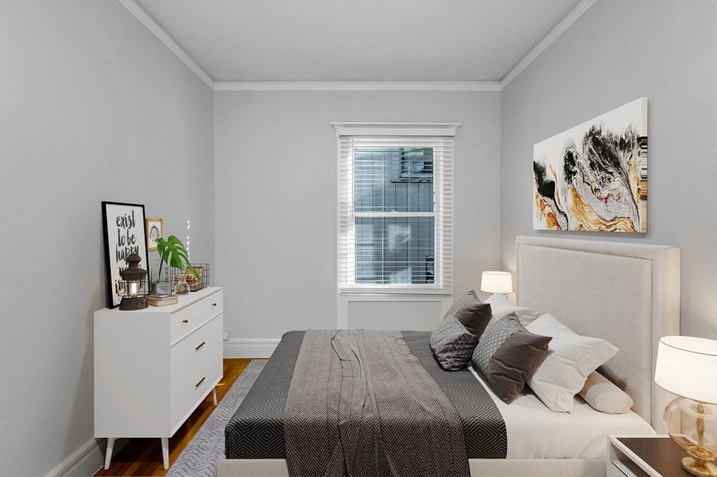 A bedroom with a bed, nightstand, and a window with blinds.
