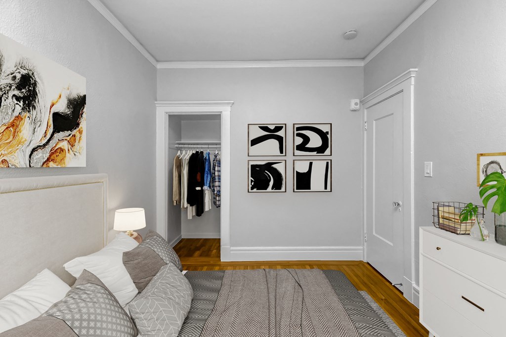 A bedroom with a bed, a dresser, and a painting on the wall.