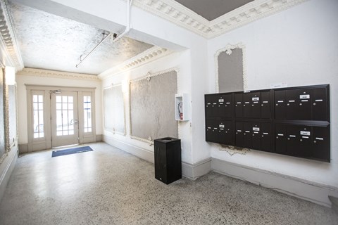A room with a blue mat on the floor and a black cabinet.