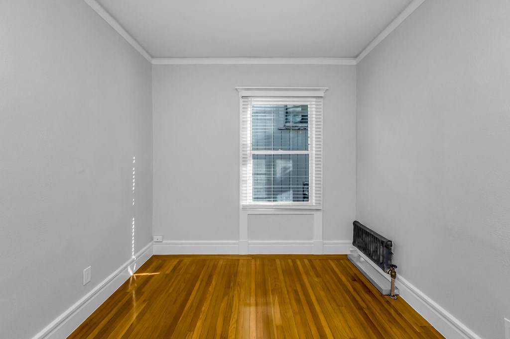 A room with a window and a radiator on the wall.