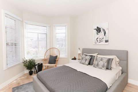 a bedroom with a bed and a chair and a painting of a dog