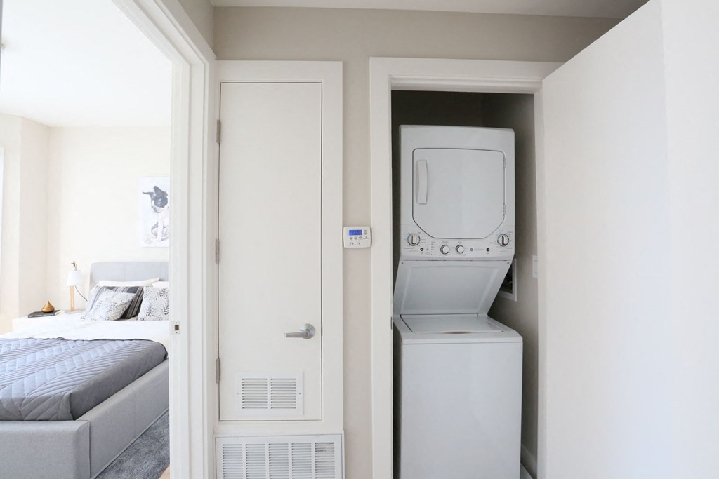 a bedroom with a washer and dryer in a closet