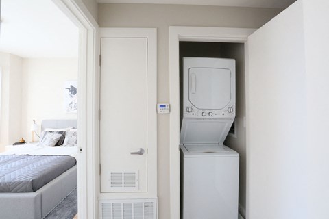 a bedroom with a washer and dryer in a closet