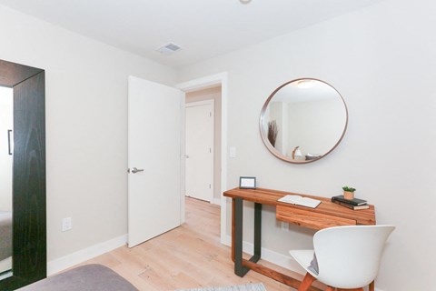 a white room with a desk and a mirror