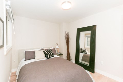 a bedroom with a bed and a mirror