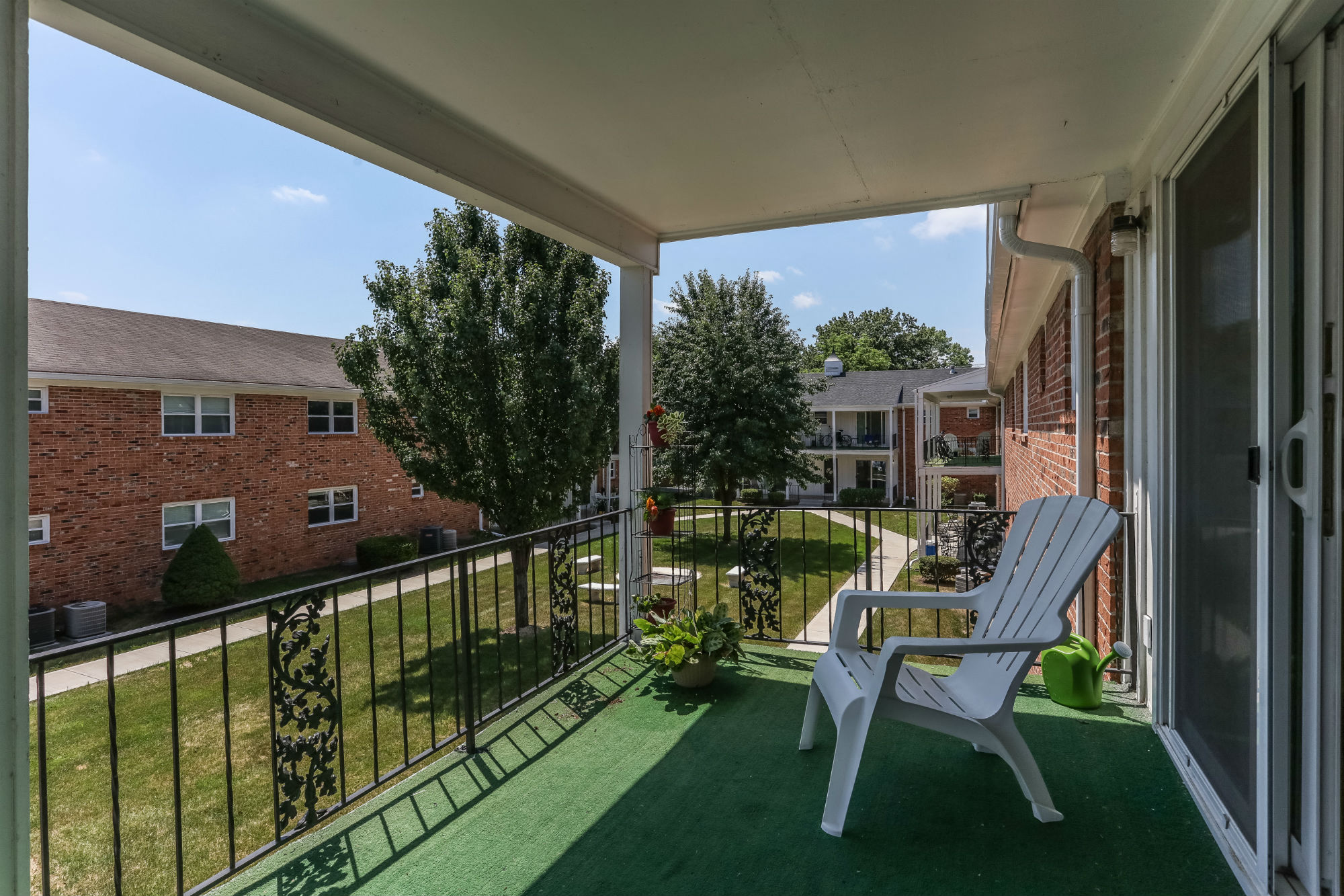 the view from the porch of a home with a white rocking chair