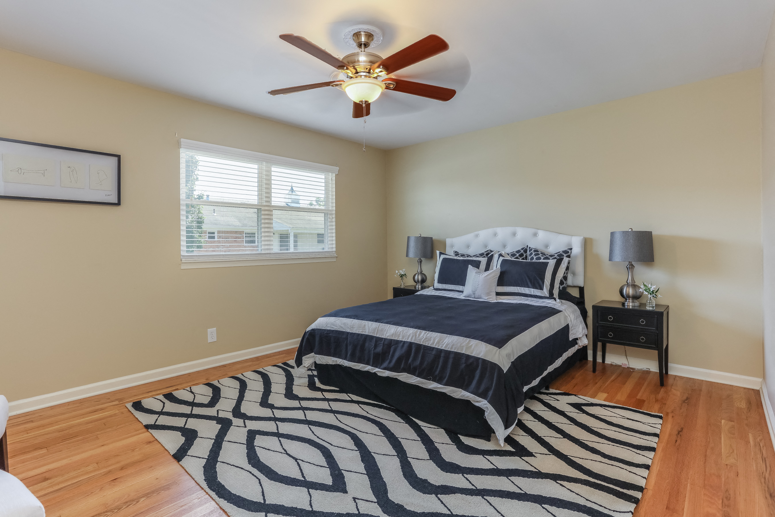 a bedroom with a ceiling fan and a bed