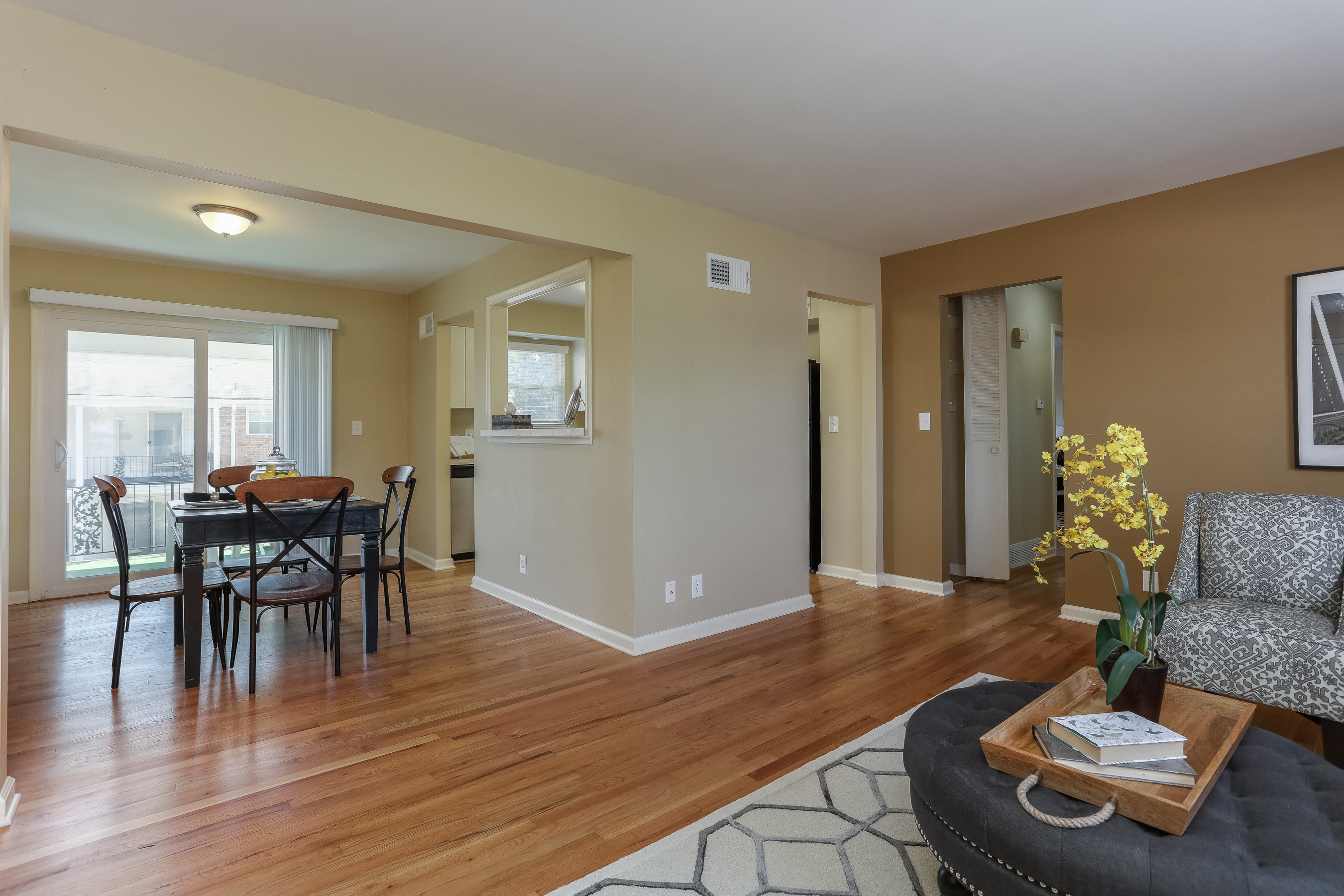 a living room and dining room with wood floors and a table and chairs