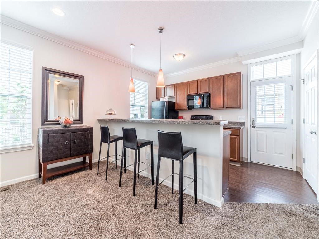 a kitchen with a counter and three chairs