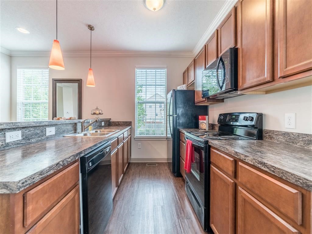 a kitchen with wooden cabinets and a black refrigerator