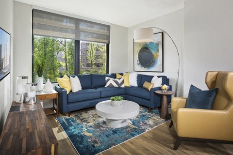 A living room with a blue couch and yellow accents.
