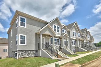 a row of townhomes with stairs and grass