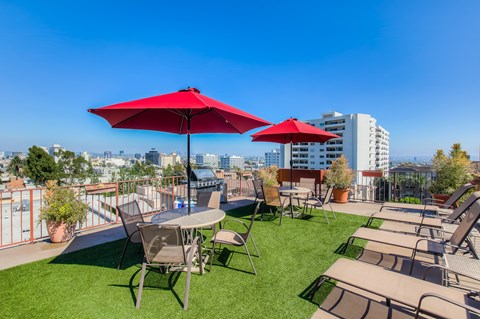 a rooftop patio with tables and chairs and umbrellas