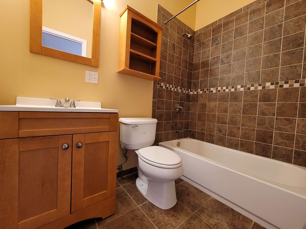 a bathroom with a toilet and a tub and a sink