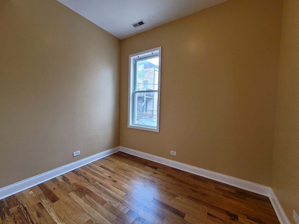 a empty room with wooden floors and a window