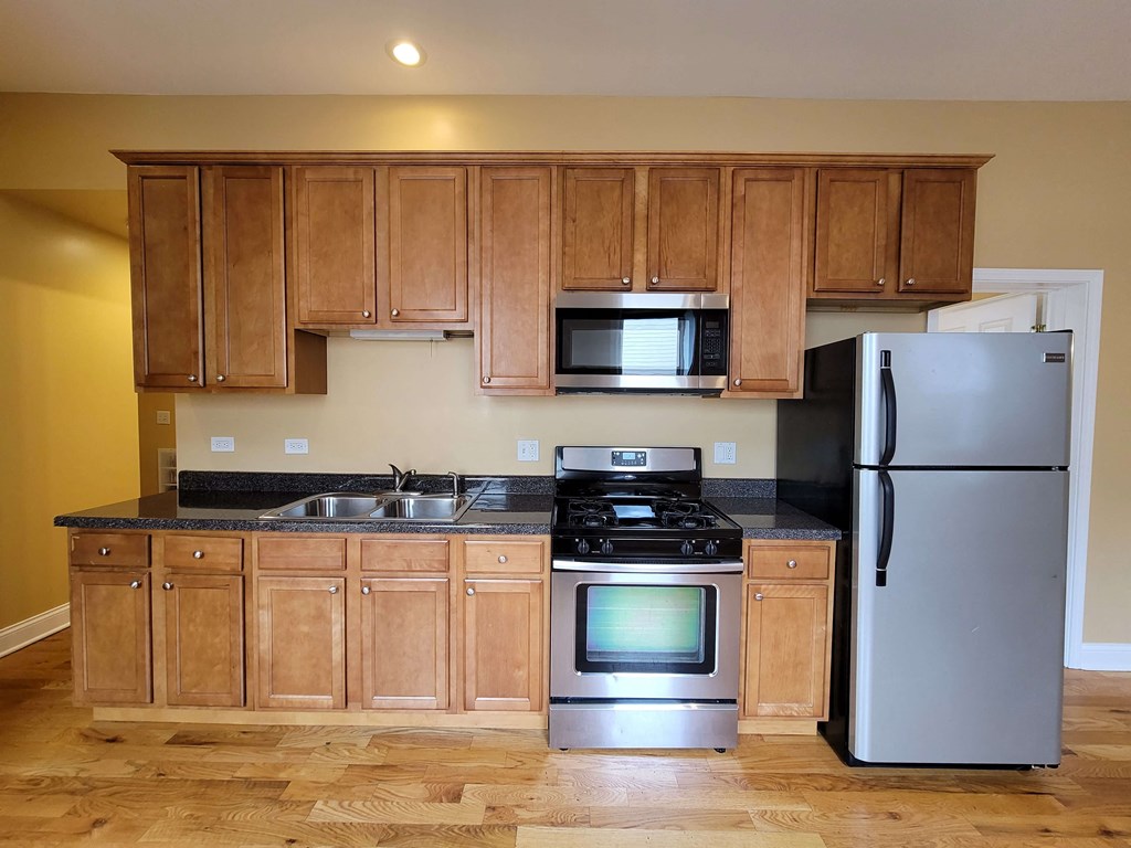 a kitchen with stainless steel appliances and wooden cabinets