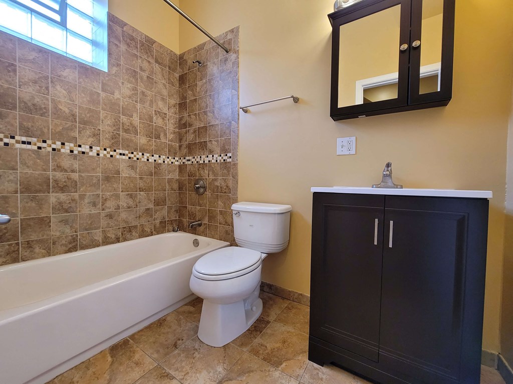 a bathroom with a toilet and a tub and a sink