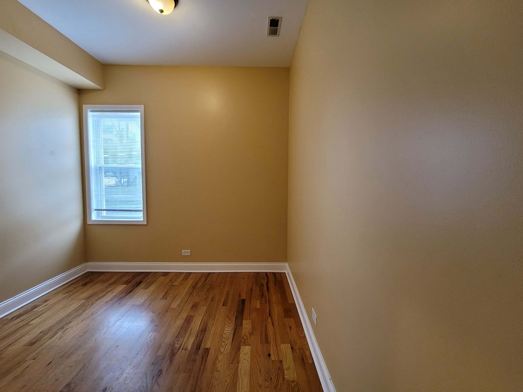 a empty room with wooden floors and a window