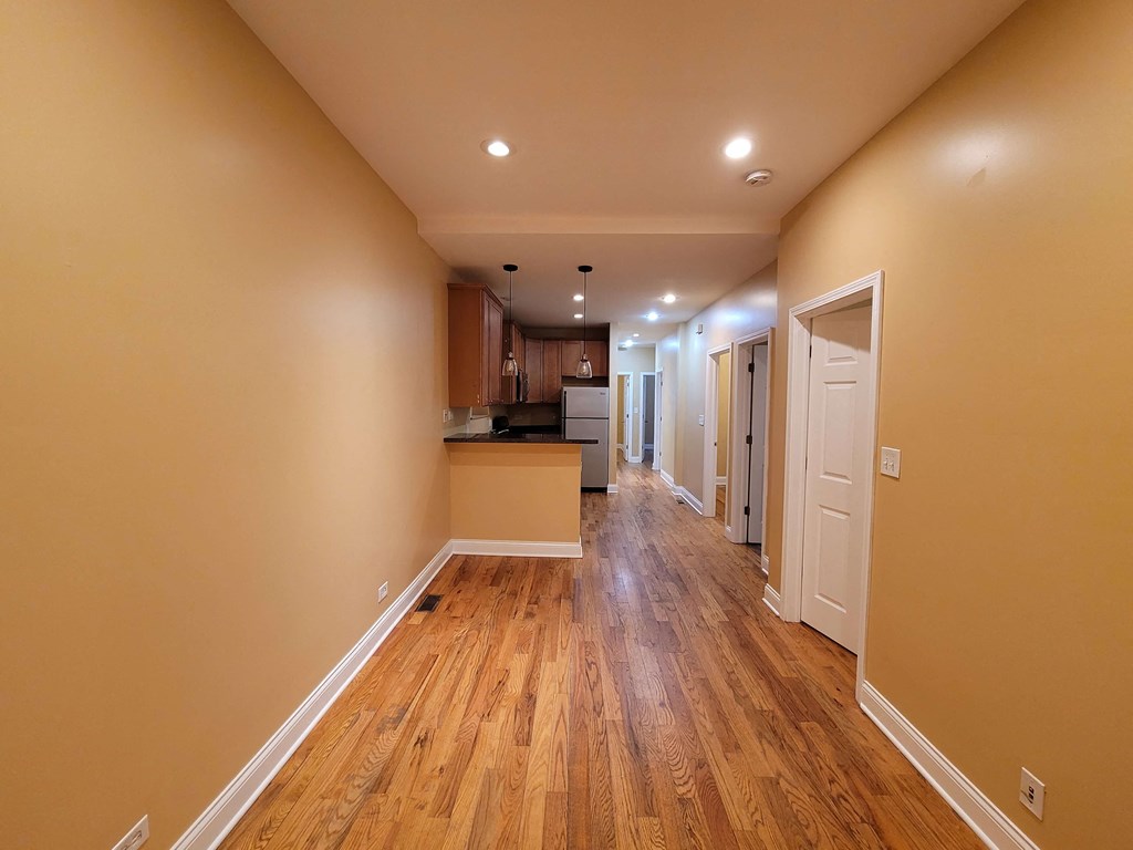 a renovated living room and kitchen with wood floors