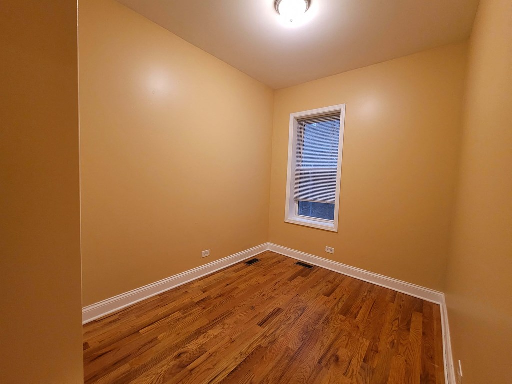a bedroom with a hard wood floor and a window