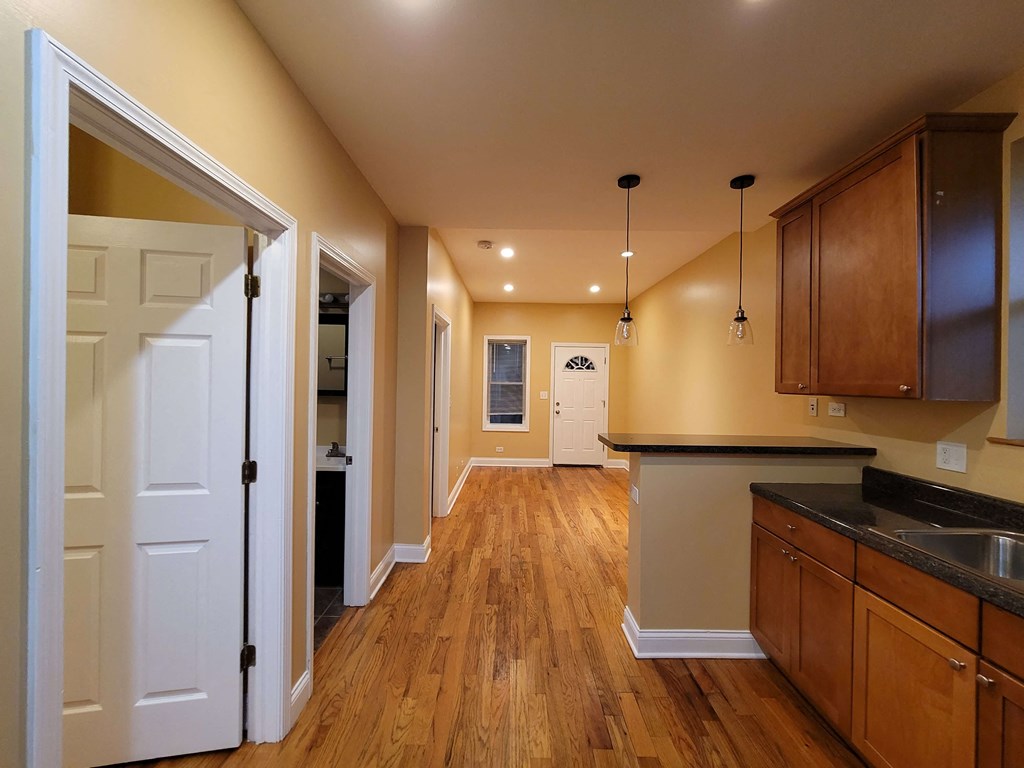a kitchen with wooden floors and a white door