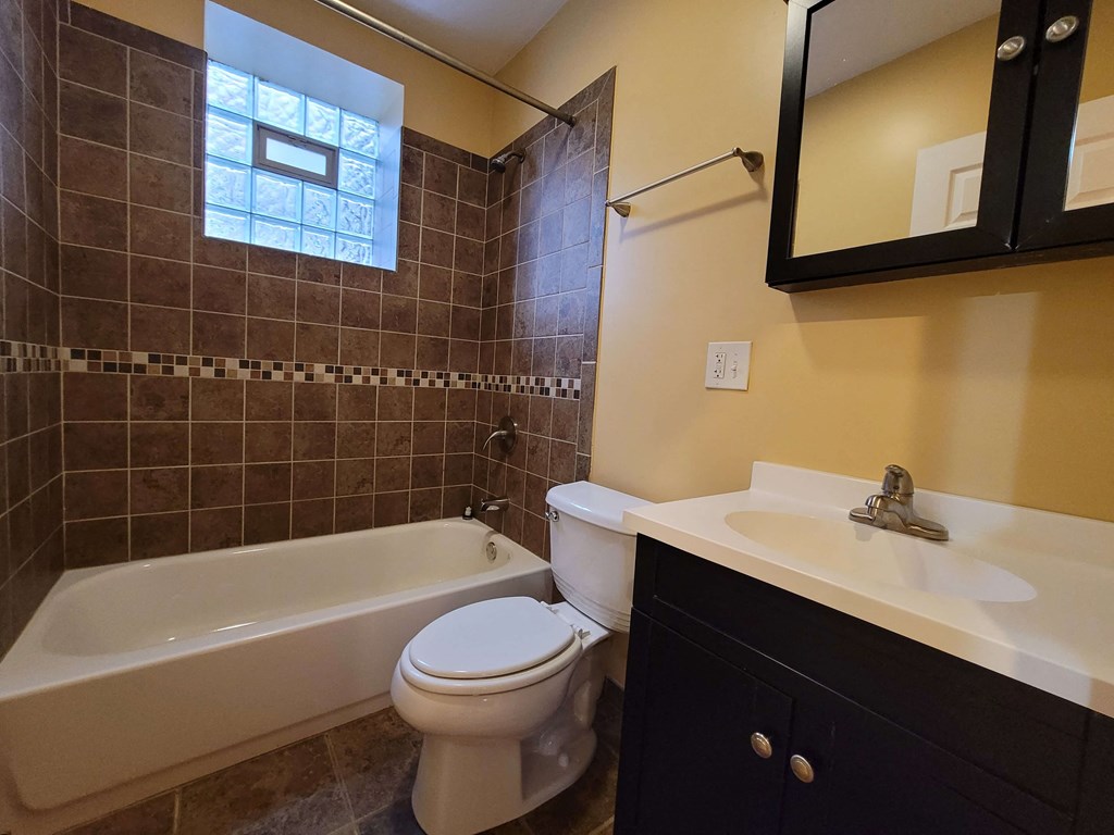 a bathroom with a toilet and a tub and a sink