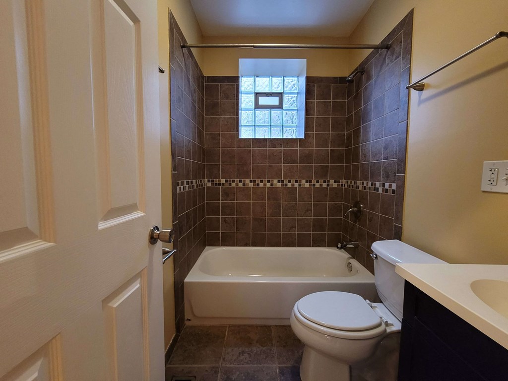 a bathroom with a toilet and a tub and a sink