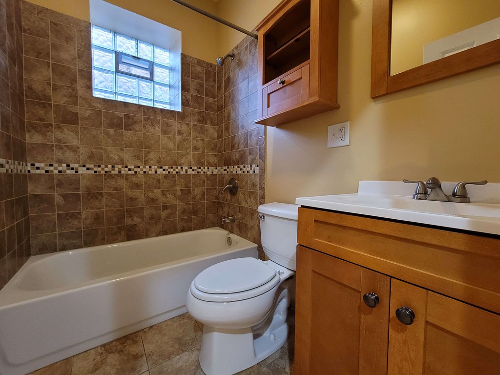 a bathroom with a toilet and a tub and a sink