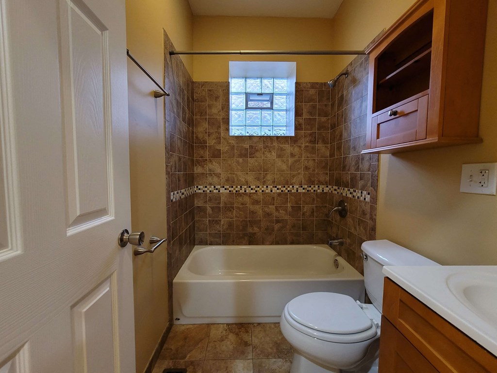 a bathroom with a toilet and a tub and a sink