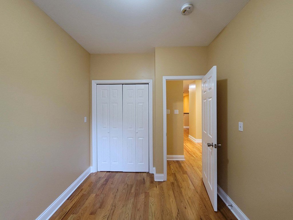 a bedroom with a closet and a door open to a hallway