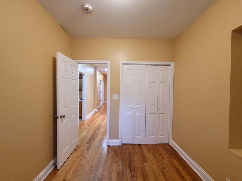 a bedroom with two closets and a door to a hallway