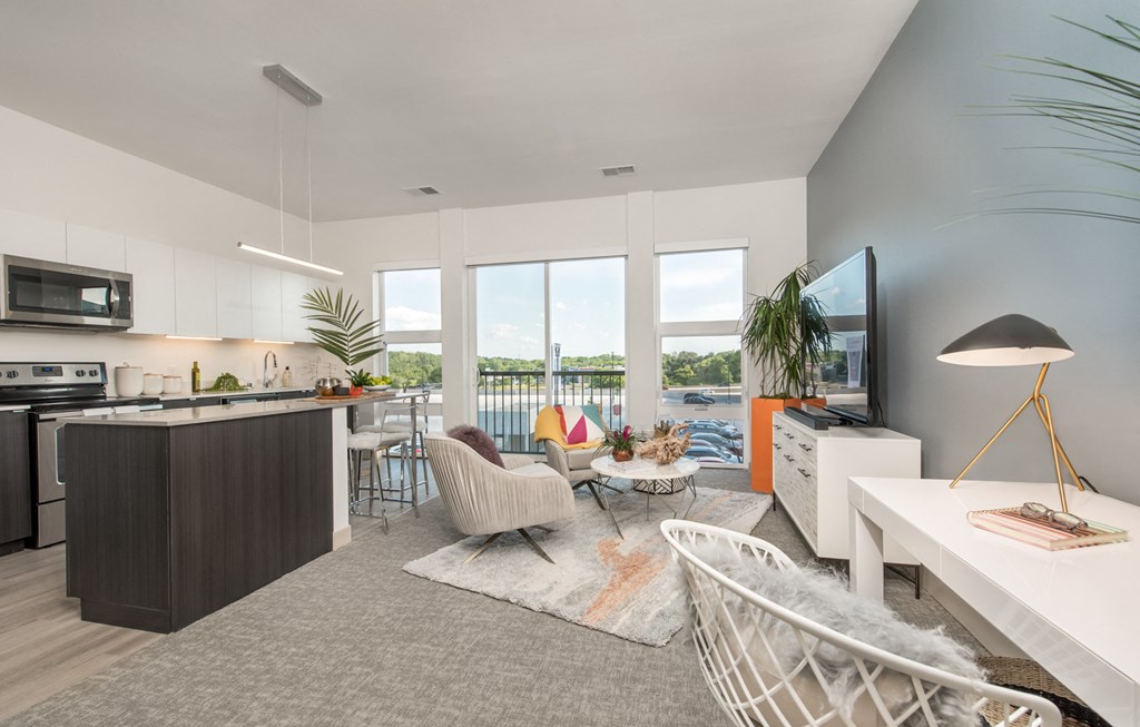 furnished living room and kitchen with views of the pool and lake in a modern apartment