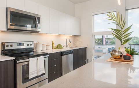 a kitchen with stainless steel appliances and a counter top and a window