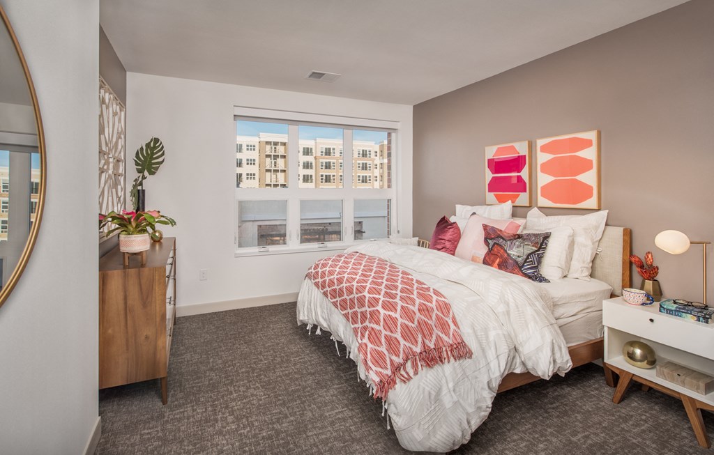 a bedroom with a bed and a large window