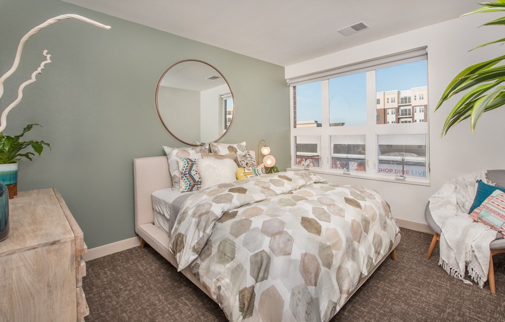 a bedroom with a large bed and a large window