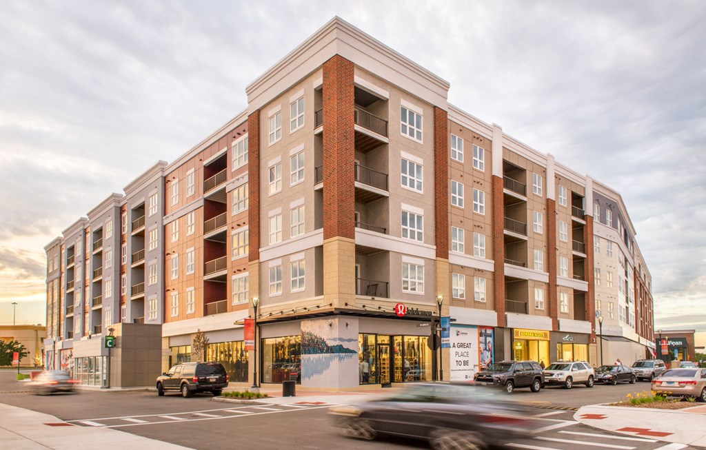 an apartment building on the corner of a busy street with cars
